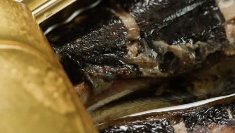 opening sardine fish or tuna can, man open the canned anchovy on the table. close up on professional kitchen.