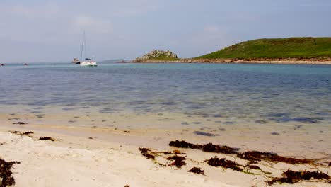 extra wide shot of the rock formation on the island of gugh and taken from the sandbar on st agnes at the isles of scilly