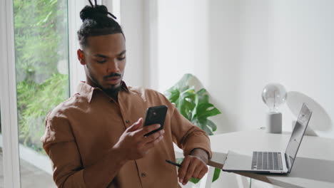 serious man reading cellphone message in apartment closeup. guy looking screen