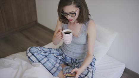 woman with coffee browsing smartphone