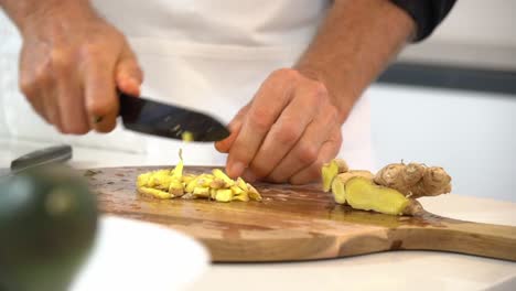 slicing ginger on cutting board to make sauce for zoodles to make zucchini noodles zoodles adding to bowl healthy vegan vegetarian lifestyle diet detox