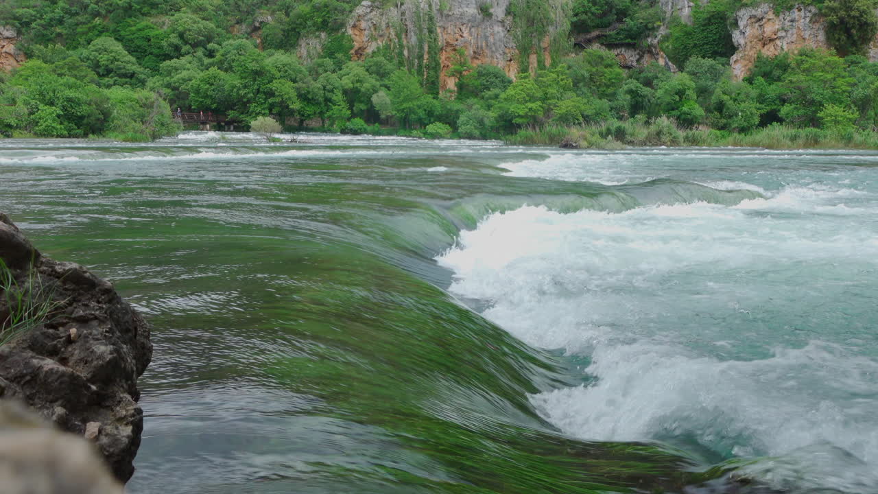 Eau claire en forme de vague avec des algues dans le parc de Krka.