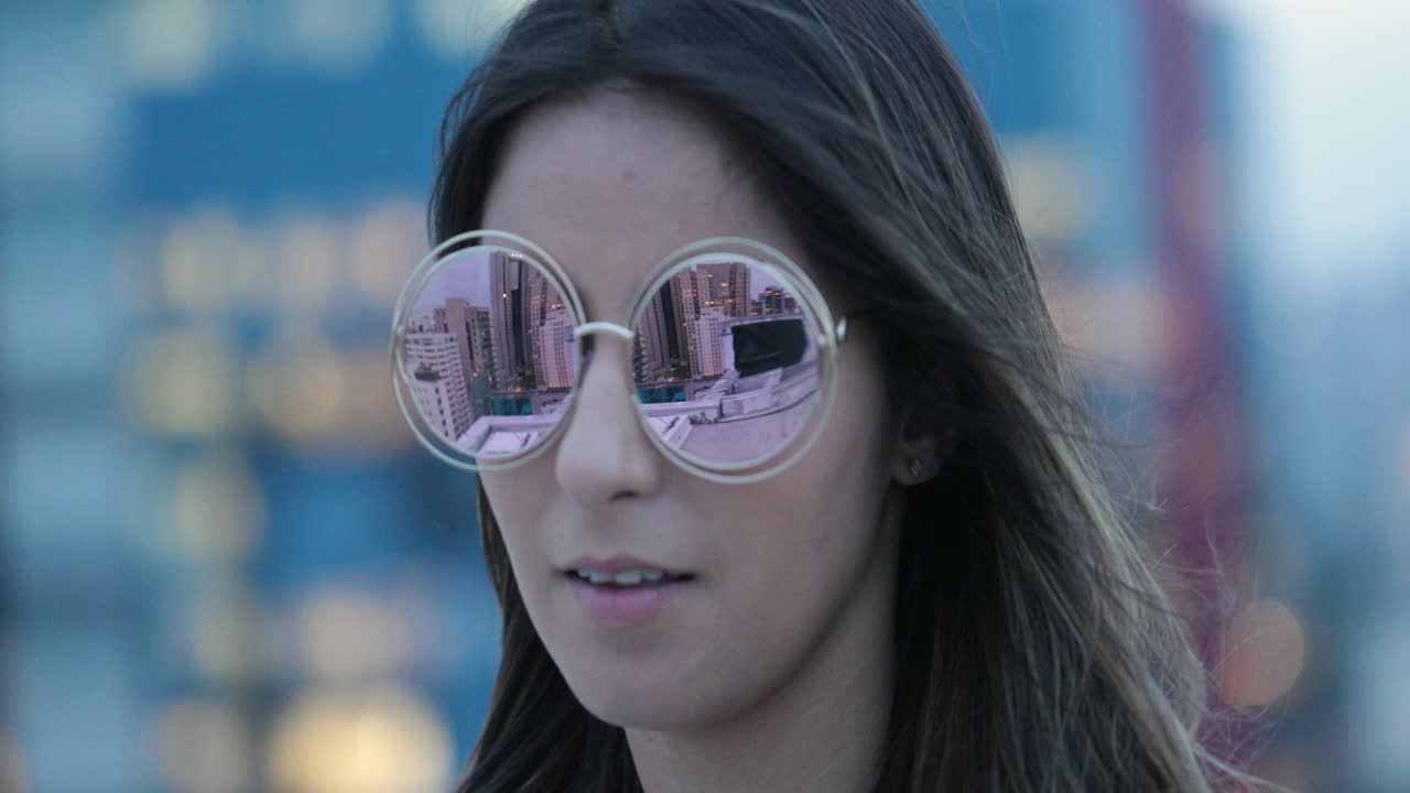 chica con gafas de sol grandes y redondas al aire libre por la noche