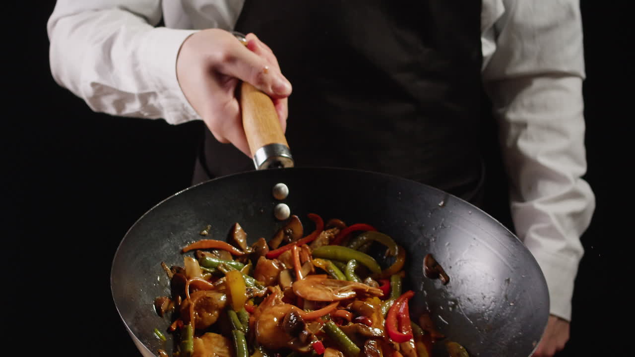Chef Stir-Frying Shrimp and Vegetables in a Wok