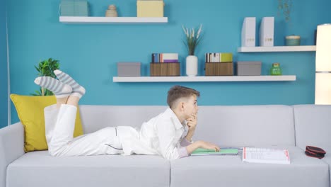 el niño que cierra su cuaderno y sueña después de estudiar.