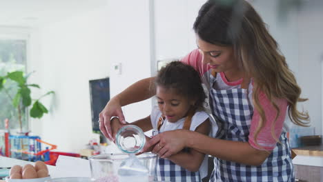 Madre-E-Hija-Hispanas-Divirtiéndose-En-La-Cocina-Horneando-Pasteles-Juntos