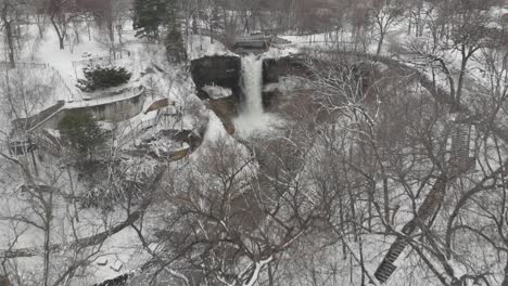 Aerial-footage-of-a-winter-landscape-revealing-a-waterfall,-Minnesota,-minehaha,-cloudy