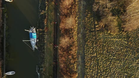 birds eye view runners running along canal with boat, nature landscape, sweden