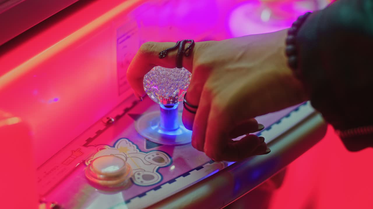 Persona che gioca a un videogioco arcade con un joystick a sfera di cristallo