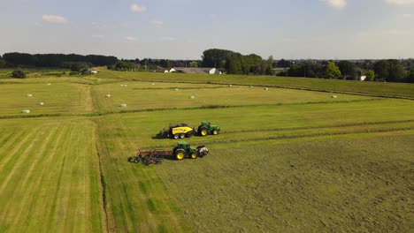 rotating drone shot of two tractors working with hay in rhenen, the netherlands