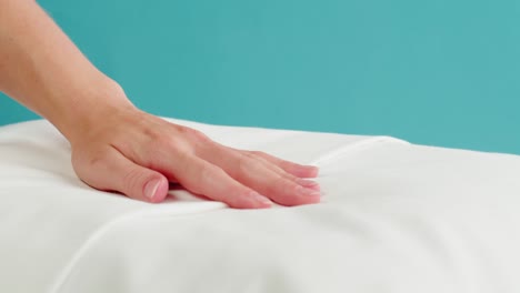 hand touching a white pillow