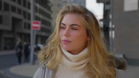 beautiful young woman poses confidently on a city street