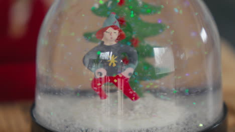 close-up of a christmas snow globe with a festive character and tree