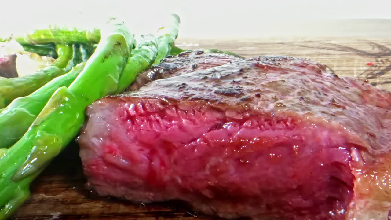 Succosa bistecca con asparagi freschi su tagliere di legno, deliziosa e invitante