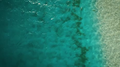 Drone-footage-flying-over-a-clear-blue-Caribbean-Sea-in-Los-Roques,-Venezuela