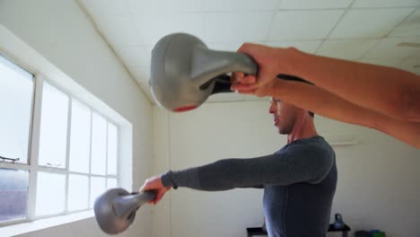 Man-and-woman-exercising-with-kettlebell-4k