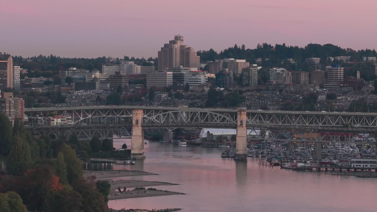 Aerial telephoto descending dolly shot of the Burrard and Granville bridges during sunset in Vancouver, British Columbia, Canada. 4K