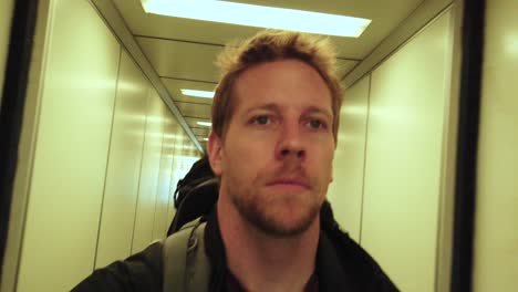 man selfie walking through tight airport corridor