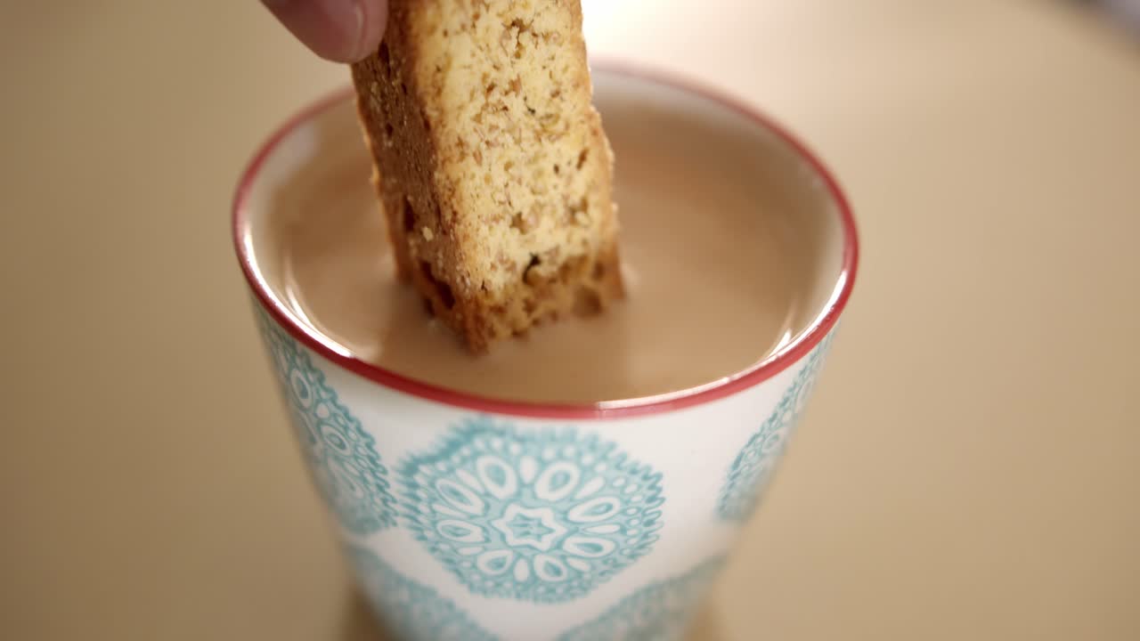 커피 한 잔에 비스코티를 담그고 있다