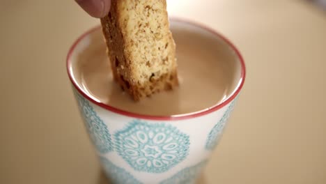 biscotti being dipped in a cup of coffee