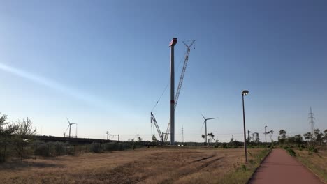 a wind turbine is being set up by a crane in lommel, belgium