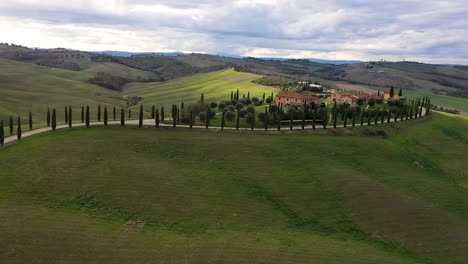 aerial view of amazing landscape scenery of tuscany in italy - farmhouse,hills fields, vineyards, cypress trees along white road