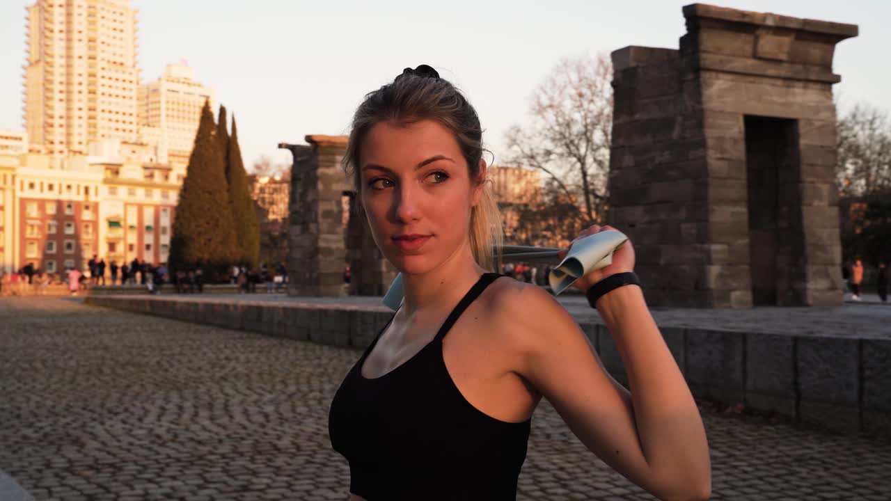Mulher jovem, ativa e saudável alongando-se ao ar livre com faixa elástica, Espanha.