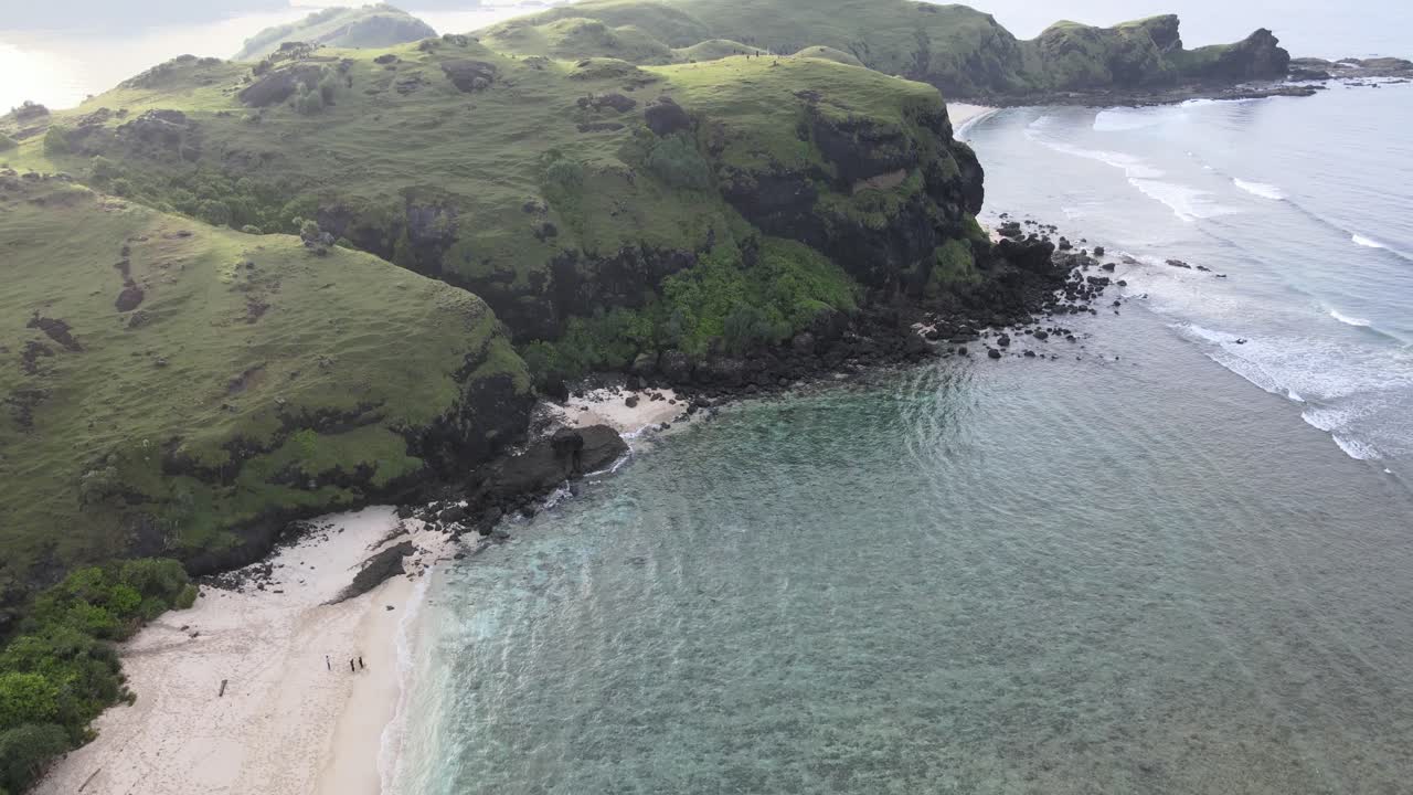 Vista aérea de costa tropical con colinas verdes y aguas cristalinas del océano