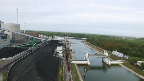 High-altitude-Drone-flight-over-a-river-with-a-big-modern-coal-power-plant-in-Europe-on-a-day-with-overcast-skies