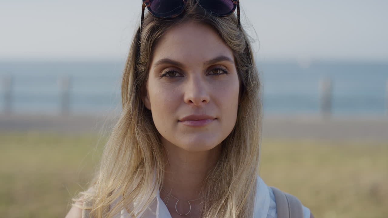 портрет уверенной в себе молодой женщины, улыбающейся, счастливой, наслаждающейся успешным независимым образом жизни на теплом солнечном дне на берегу моря