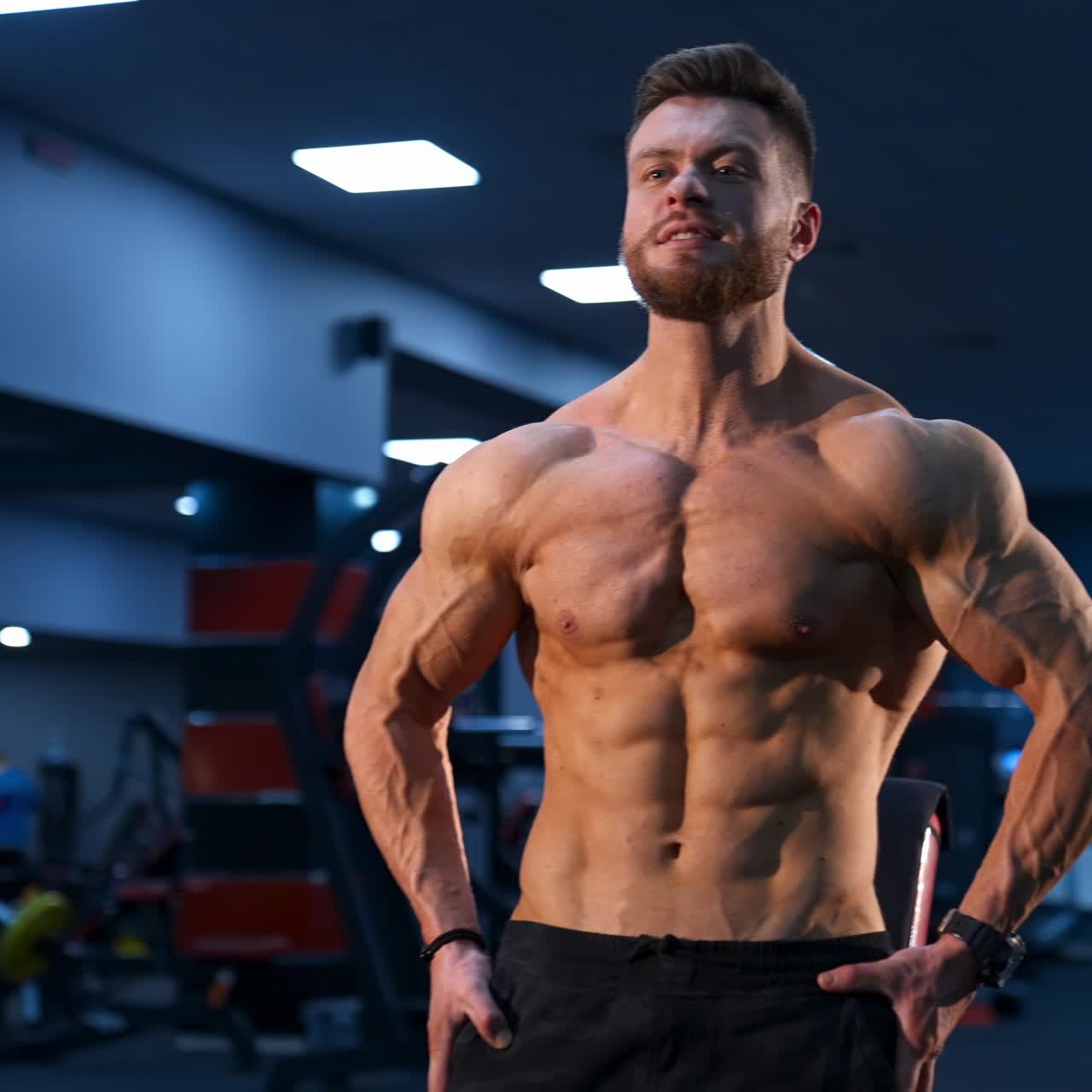 Brutal strong bodybuilder pumping up muscles. Bodybuilding and indoor sports concept. Slow motion