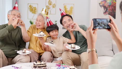 a joyful family celebrates a birthday, forming heart shapes with hands, captured in a bright, cheerful setting