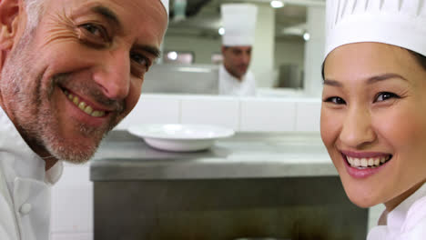 Chef-smelling-colleagues-sauce-and-smiling-at-camera