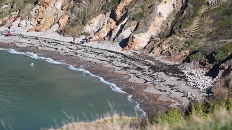 Waves-crashing-on-a-sandy-beach-in-lulworth-cave,-south-of-England