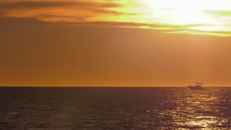 Lancha-En-El-Horizonte-Con-Luz-Solar-Dorada-En-El-Agua,-Costa-Mediterránea,-España