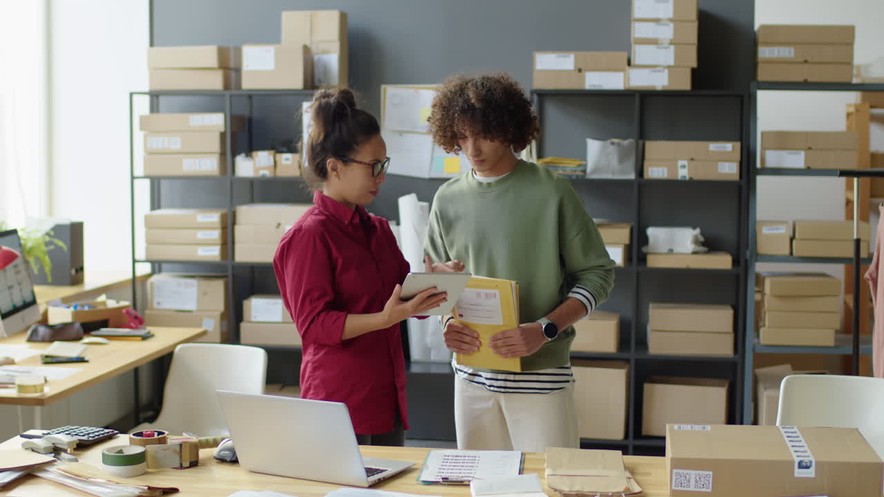 Two colleagues discussing work in a warehouse office