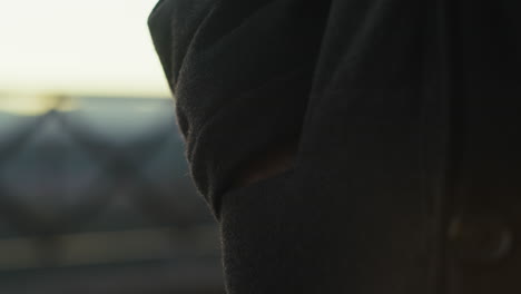 la mano de un anciano se mete en el bolsillo de una chaqueta.