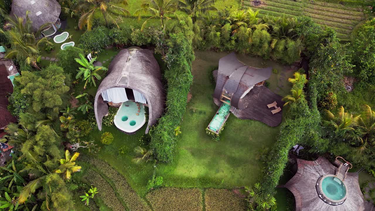 Drone video captures a unique bamboo houses with a turquoise pool hidden in lush vegetation of Sidemen, Bali. This eco-inspired tropical retreat highlights sustainability and tranquil island beauty