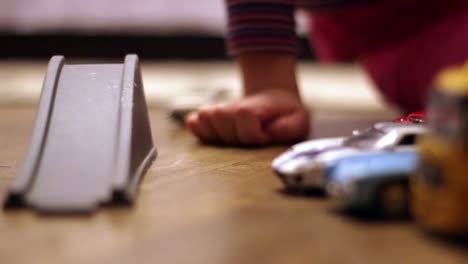 child kid plays with a red pickup toy car