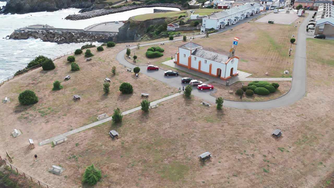 Breathtaking aerial footage captures the peaceful hermitage of La Atalaya, a charming chapel perched on a cliff with panoramic views of the Cantabrian Sea in Navia, Asturias