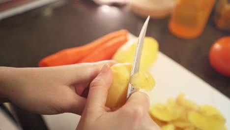 Manos-Femeninas-Pelando-Patatas-En-La-Cocina-A-Cámara-Lenta