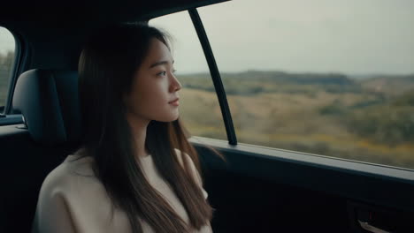 a young woman looking out the car window during a road trip