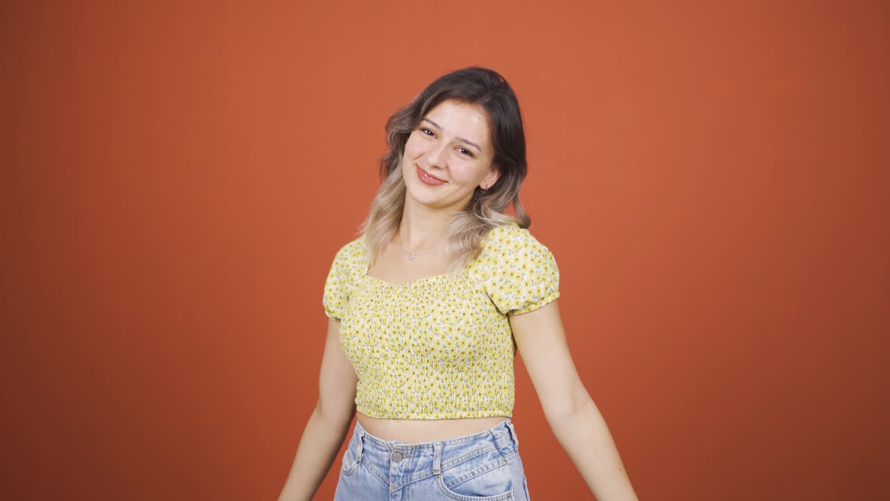 젊은 여성이 카메라에 심장 표시를 하고 있습니다.