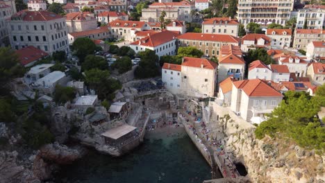 Gente-Nadando,-Saltando-Acantilados-En-La-Playa-Sulic-En-La-Bahía-De-Kolorina,-Dubrovnik,-Croacia