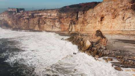 Blick-Auf-Den-Felsigen-Strand-Mit-Tosenden-Wellen-In-Nazare,-Portugal