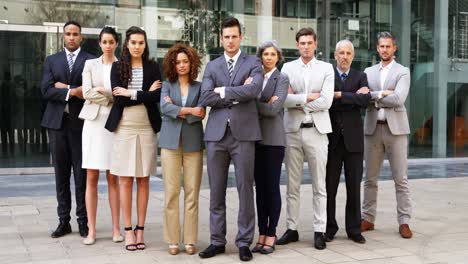 business people standing with arms crossed in office building