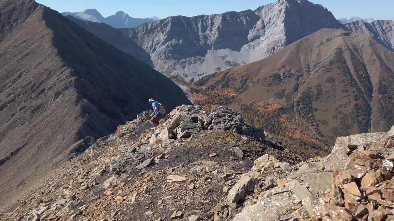 excursionista saltando por las rocas por encima de la cordillera corriendo siguió a cámara lenta kananaskis alberta canadá