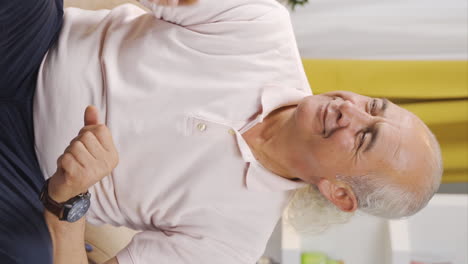 video vertical de un anciano feliz bailando en casa.