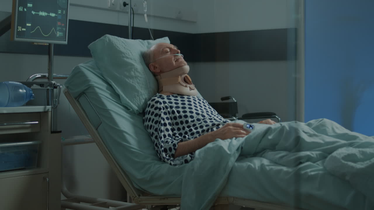 Old patient with cervical neck collar laying in hospital ward
