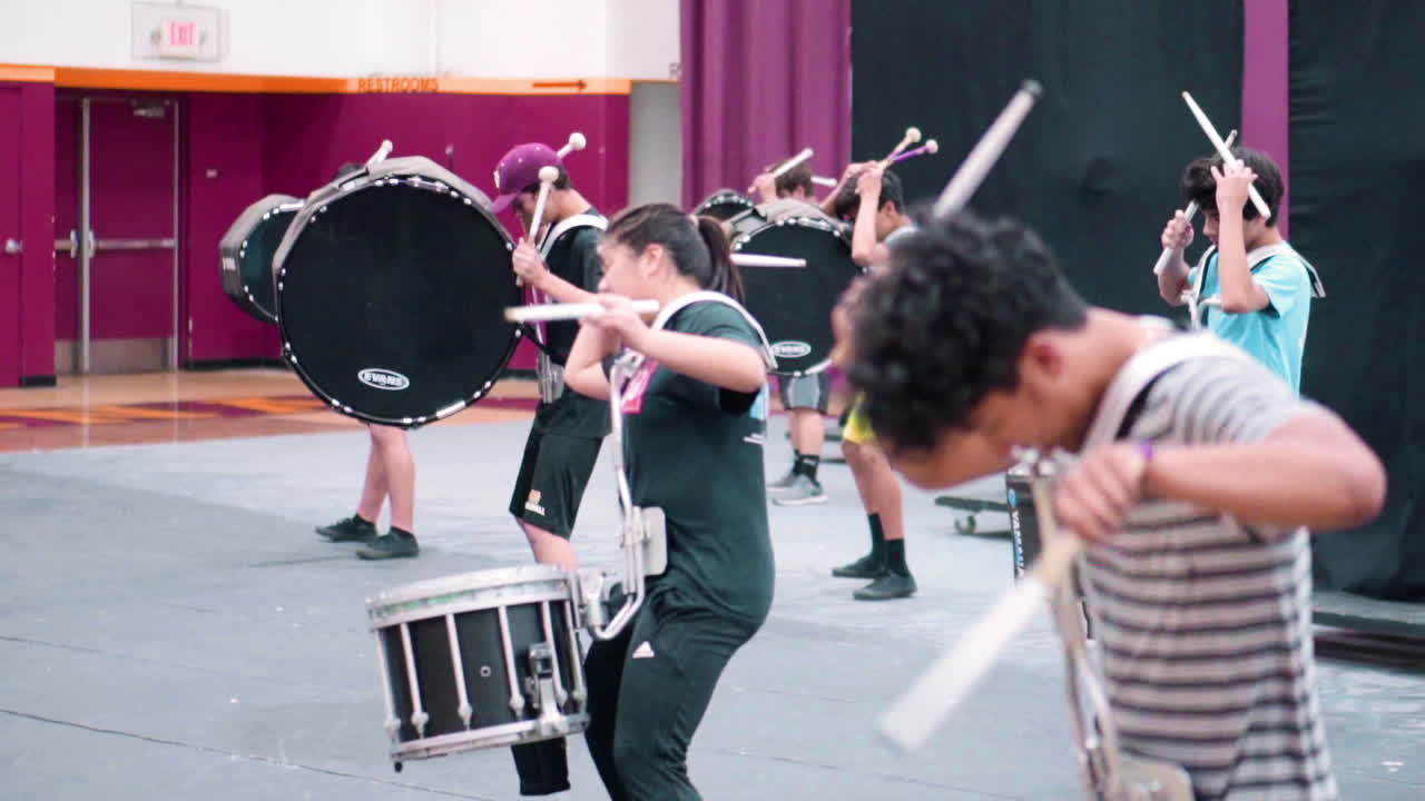High school students rehearsing music and movement to the show they are to perform.